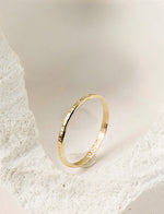 Gold filled ring on a light beige stone background
