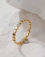 Gold filled ring with small round beads and a central moissanite on a white background