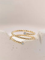 Gold filled twisted ring with moissanite accents on a white/gray stone background