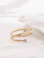 Gold filled twisted ring with moissanite accents on a white background