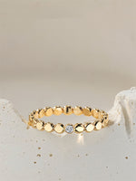 Gold filled ring with small round beads and a central moissanite on a light beige stone