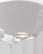 Gold filled ring on a white stone background