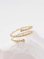 Gold filled twisted ring with moissanite accents on a white background