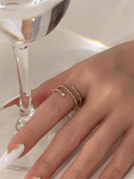 Gold filled twisted ring with moissanite accents on a models hand near a wine glass