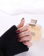 Gold filled ring on a hand with a cologne in the background