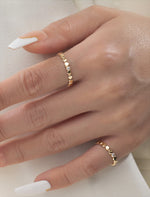 2 Gold filled rings with small round beads and a central moissanite on a models hand