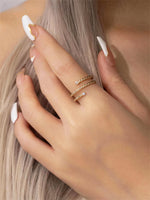 Gold filled twisted ring with moissanite accents on a models hand