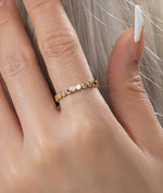 Gold filled ring with small round beads and a central moissanite on a models hand
