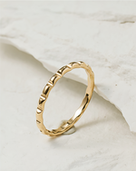 Gold filled ring with textured band on a marble surface