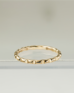 Gold filled ring with a textured band on a light gray background