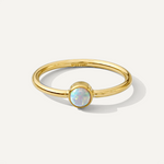 Gold filled ring with a central opal stone on a white background