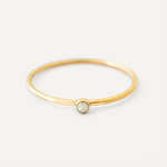 Gold filled ring with a central gemstone on a light gray background