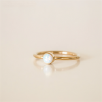 Gold filled ring with a central opal stone on a white background