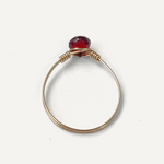 Gold filled ring with a red gemstone on a white background