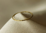 Gold filled ring on a gray cloth background