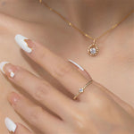 Girl's hand showcasing Nix Moissanite gold filled ring with a necklace in the background