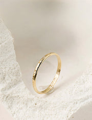 Gold filled ring on a light beige stone background