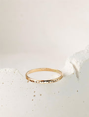 Gold filled ring on a white stone background