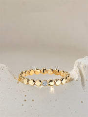 Gold filled ring with small round beads and a central moissanite on a light beige stone