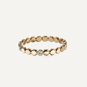 Gold filled ring with small round beads and a central moissanite on a light beige background