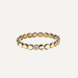 Gold filled ring with small round beads and a central moissanite on a light beige background