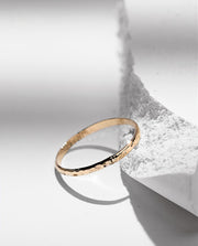 Gold filled ring on a white stone background