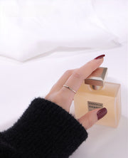 Gold filled ring on a hand with a cologne in the background