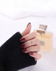 Gold filled ring on a hand with a cologne in the background