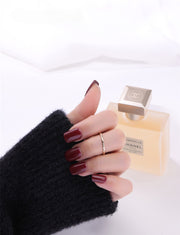 Gold filled ring on a hand with a cologne in the background