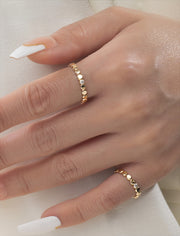 2 Gold filled rings with small round beads and a central moissanite on a models hand