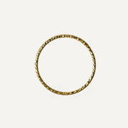 Gold filled ring with a textured design on a light beige background