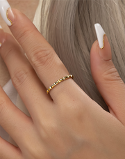 Gold filled ring on a finger with a neutral background
