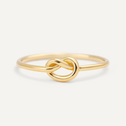Gold filled knot ring on a light beige background