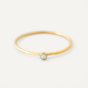 Gold filled ring with a central gemstone on a light gray background