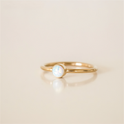 Gold filled ring with a central opal stone on a white background