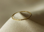 Gold filled ring on a gray cloth background